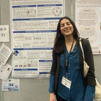 Doriana standing in front of her poster at ICAM