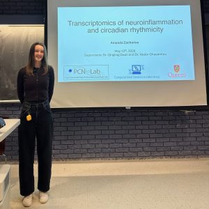 Amanda standing next to her title slide on a projector