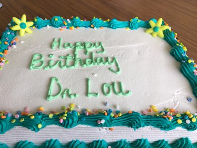 A birthday cake that says, "Happy Birthday Dr. Lou"