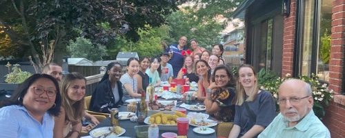 A group picture with members from both the Ghasemlou and Duan lab sitting around a table with food.