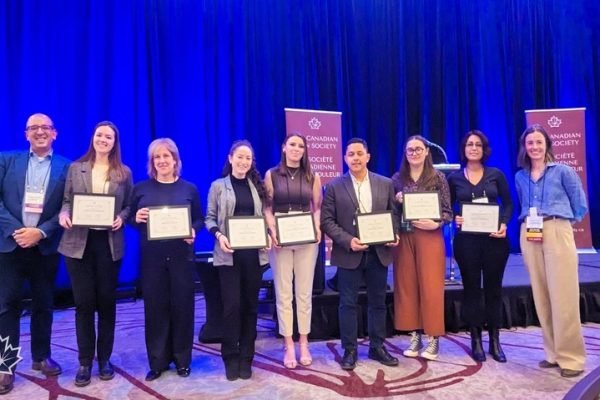 A group of people who are holding papers that indicate they won a travel award