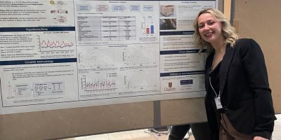 Katie standing in front of her poster about circaMS